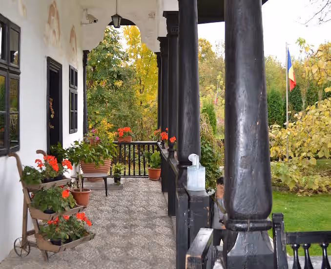 Coloane de lemn și mușcate pe prispa Conacului Bellu, Urlați Coloane de lemn și mușcate pe prispa Conacului Bellu, Urlați