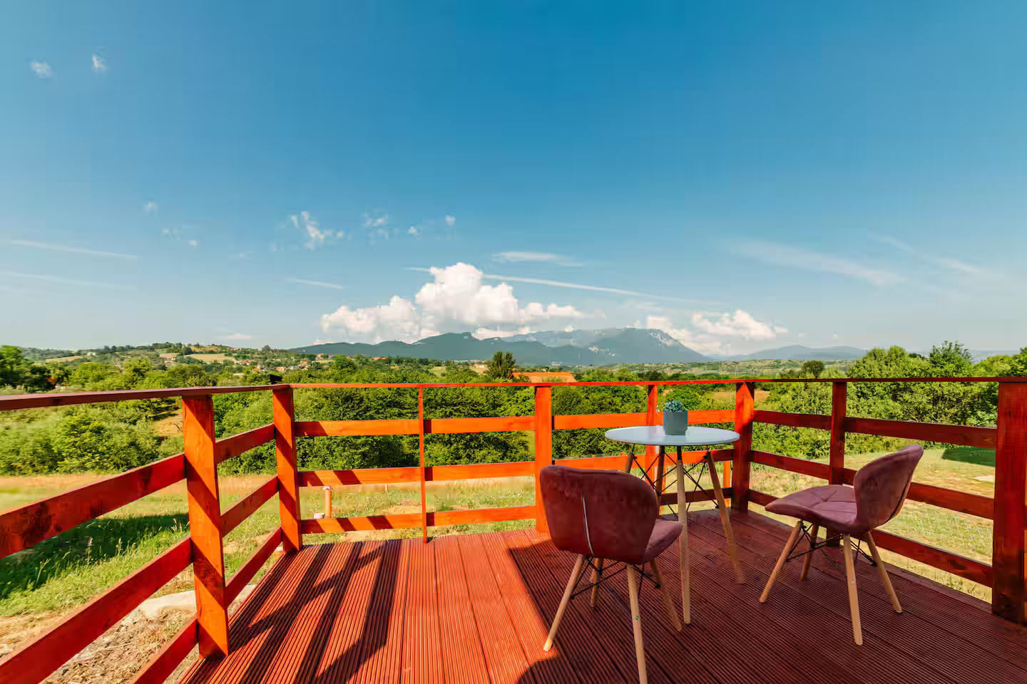 Terasa cabanei SkyAtlas Hideaway cu balustradă din lemn și vedere spre dealurile Branului Terasa cabanei SkyAtlas Hideaway cu balustradă din lemn și vedere spre dealurile Branului