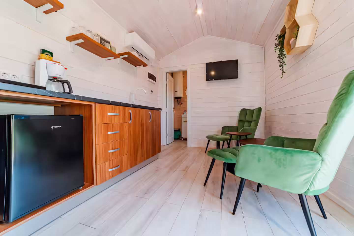 Chicinetă și fotoliu verde în cabana Forest Cabin de la SkyAtlas Hideaway Chicinetă și fotoliu verde în cabana Forest Cabin de la SkyAtlas Hideaway
