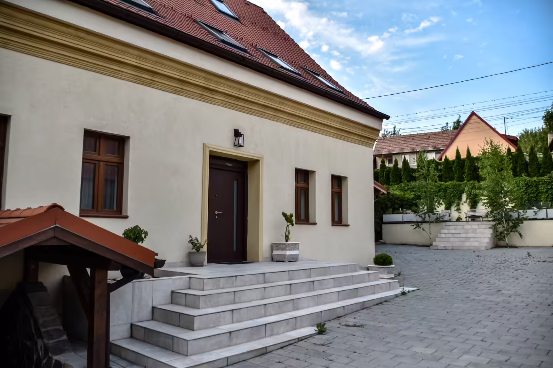 Intrarea principală în Berg House 31, cu trepte largi din piatră și copertină din lemn Intrarea principală în Berg House 31, cu trepte largi din piatră și copertină din lemn