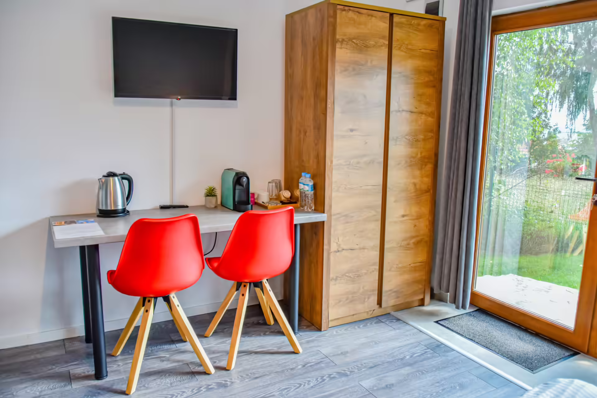 Chicinetă utilată cu masă și scaune roșii într-un bungalou Silver Bungalow