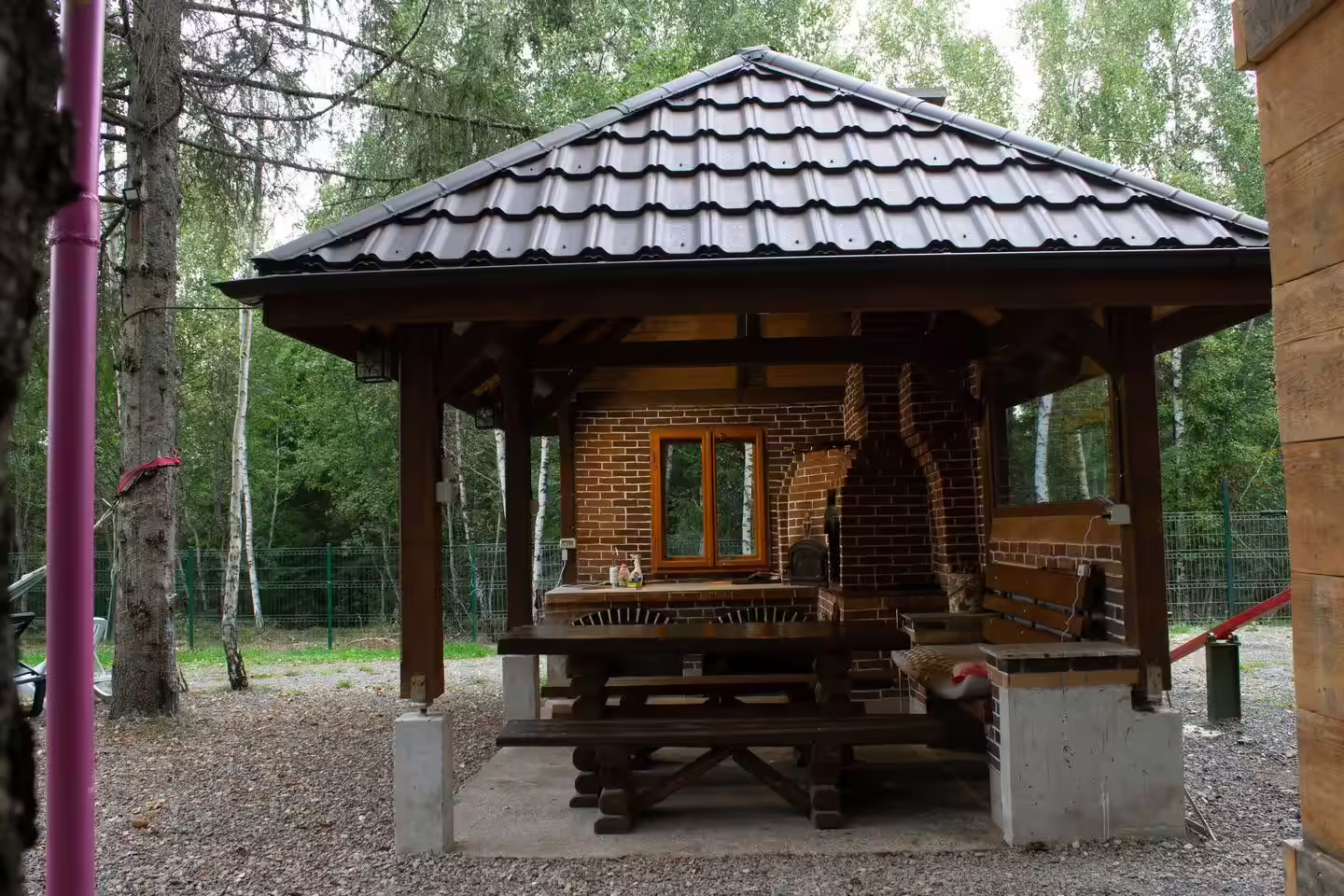 Foișor din lemn cu masă și bănci la Cabana din Pădurea Beliș