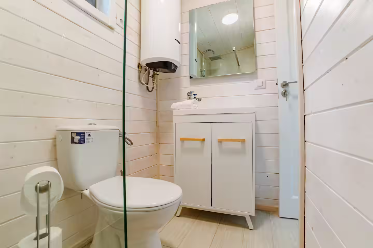 Baie modernă cu duș, lavoar și oglindă în cabana SkyAtlas Hideaway Baie modernă cu duș, lavoar și oglindă în cabana SkyAtlas Hideaway