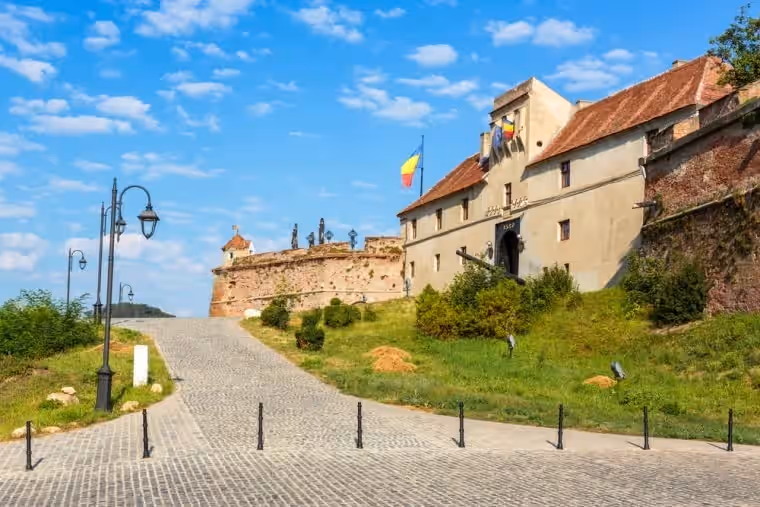 Drumul pavat spre intrarea Cetățuii de pe Strajă, cu steagul României Drumul pavat spre intrarea Cetățuii de pe Strajă, cu steagul României