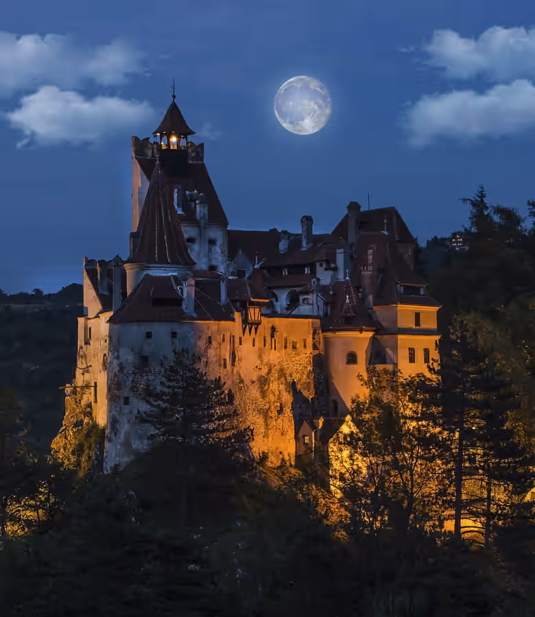 Castelul Bran pe stâncă, înconjurat de vegetație și case din Bran Castelul Bran pe stâncă, înconjurat de vegetație și case din Bran
