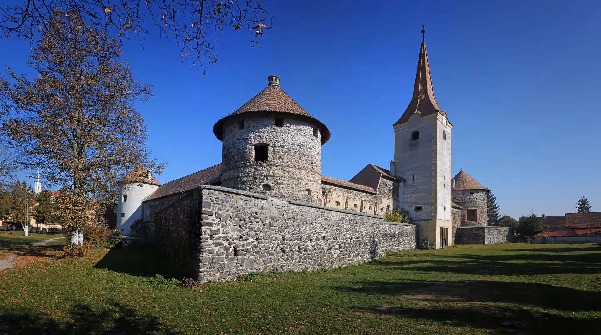 Turnul rotund al Castelului Sükösd Bethlen și biserica din Racoș Turnul rotund al Castelului Sükösd Bethlen și biserica din Racoș