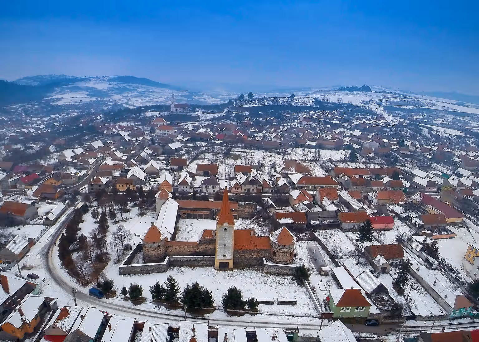 Satul Racoș acoperit de zăpadă și castelul Bethlen, vedere de sus Satul Racoș acoperit de zăpadă și castelul Bethlen, vedere de sus