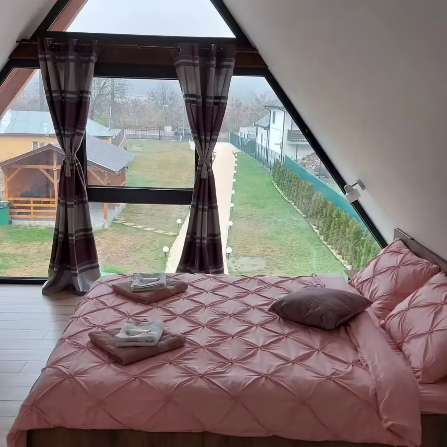 Dormitor la mansardă cu fereastră triunghiulară la Cabana A-frame Nis Dormitor la mansardă cu fereastră triunghiulară la Cabana A-frame Nis