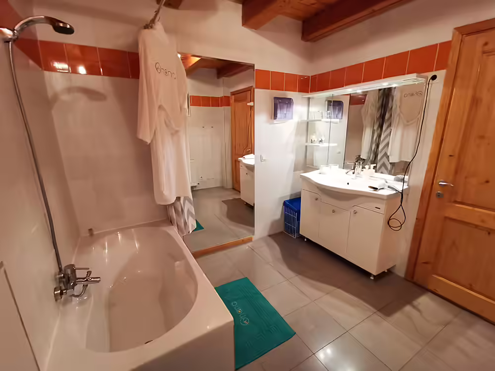 Baie cu cadă, lavoar și oglindă mare la Ohana Boutique Hotel Viștișoara