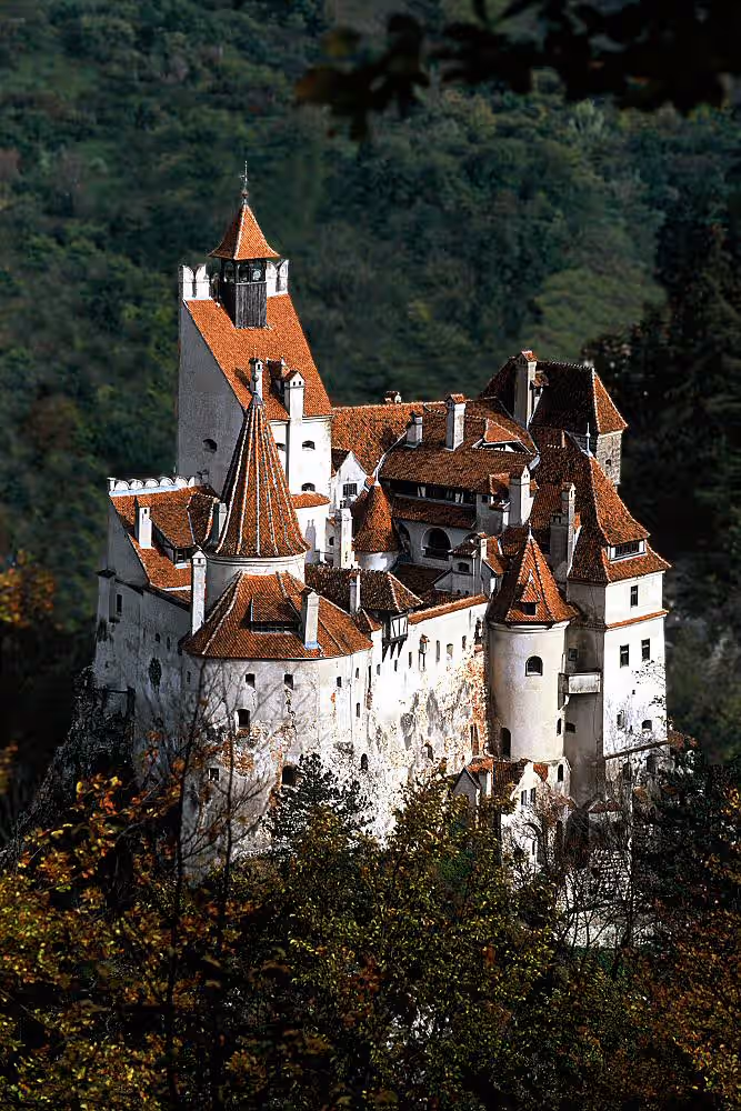 Castelul Bran în lumina apusului, cu pajiștile verzi din jur Castelul Bran în lumina apusului, cu pajiștile verzi din jur
