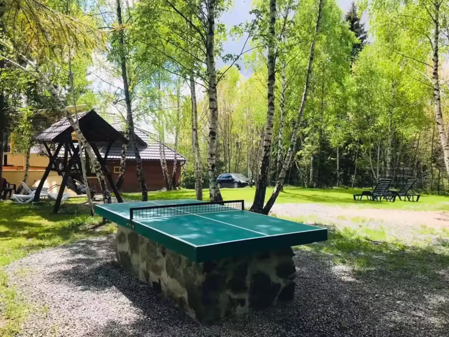 Masă de ping-pong în curtea umbrită a Cabanei din Pădurea Beliș