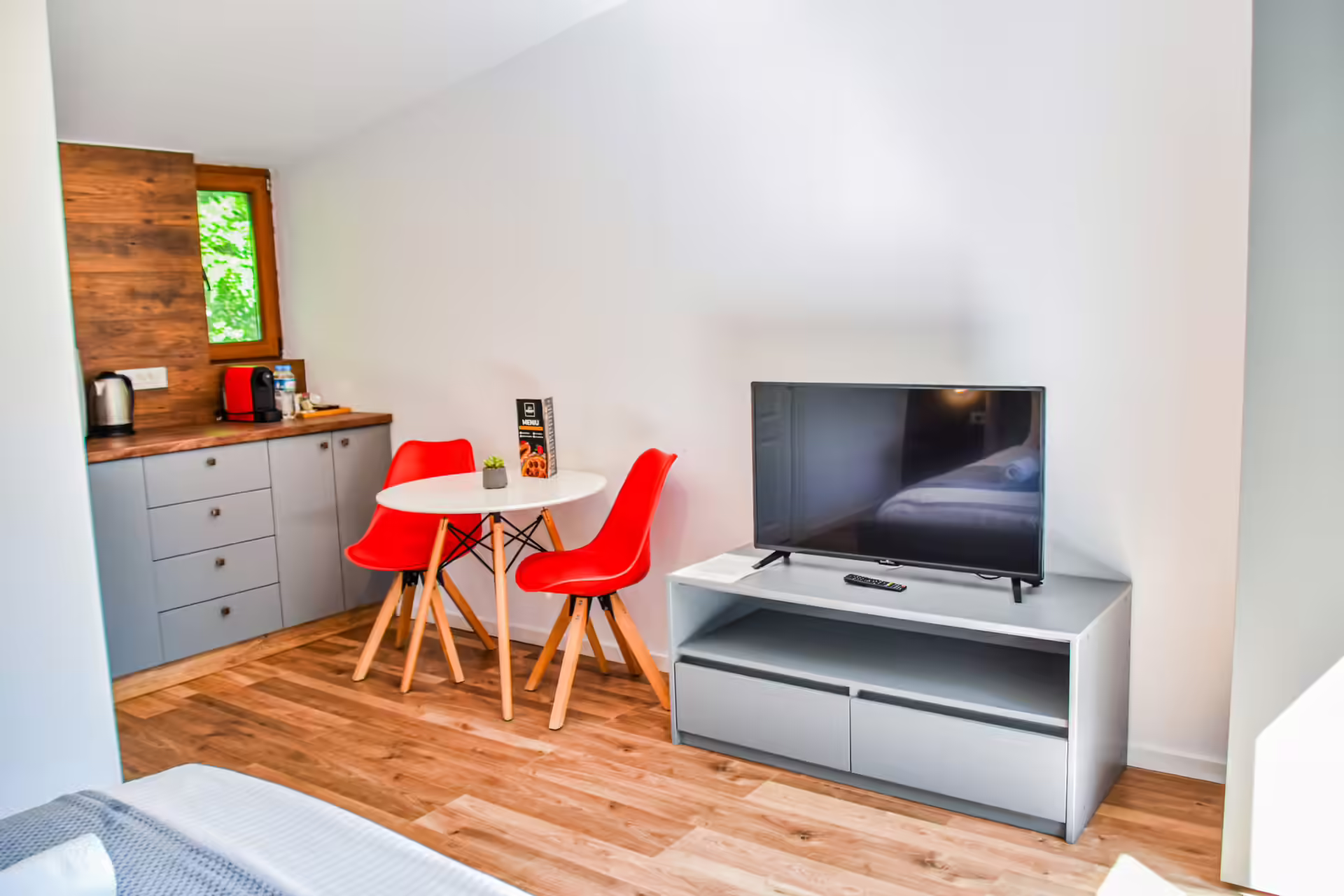 Zonă de living cu televizor și masă cu scaune roșii, Silver Bungalow