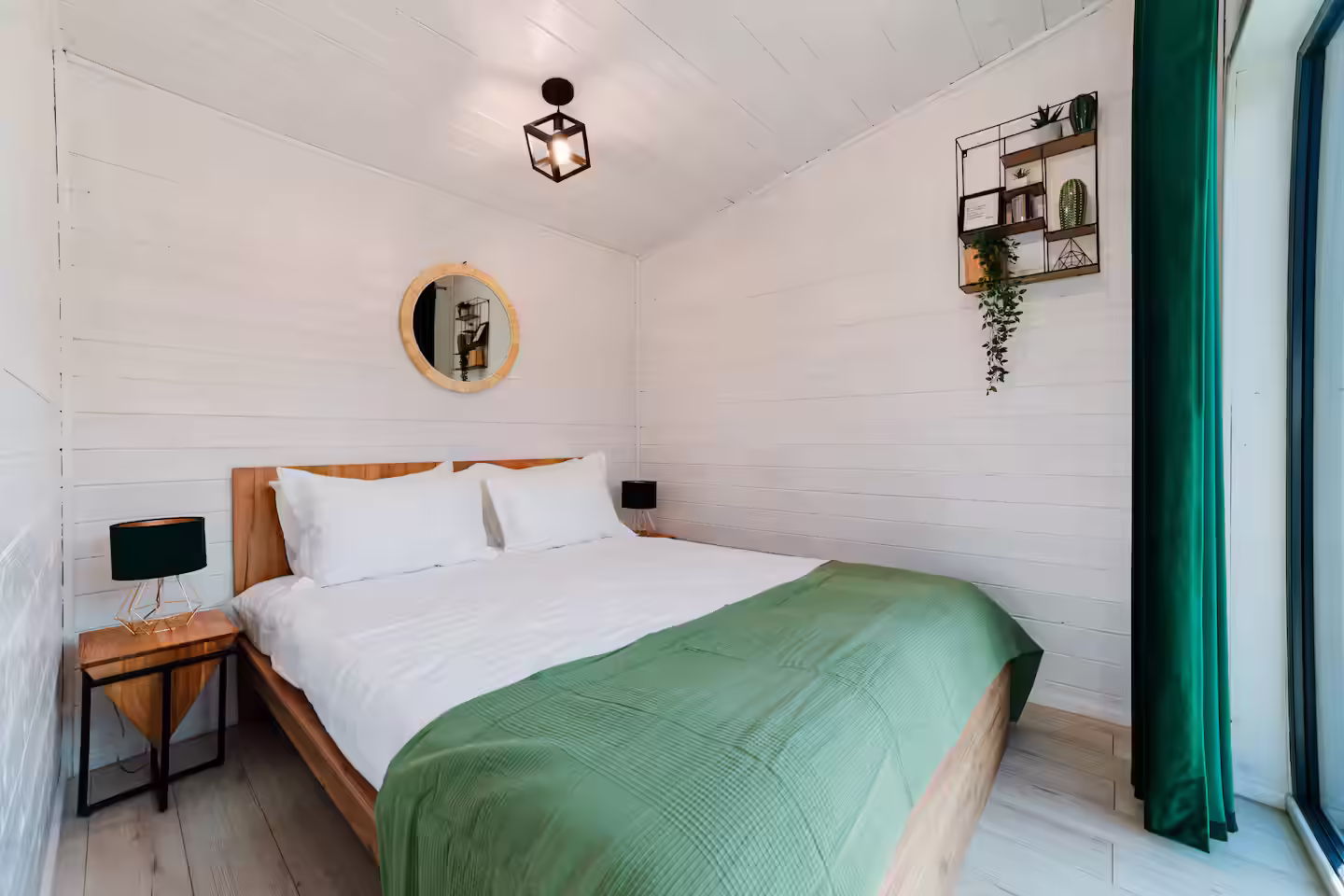 Pat dublu cu lenjerie verde și decor minimalist în cabana SkyAtlas Hideaway Pat dublu cu lenjerie verde și decor minimalist în cabana SkyAtlas Hideaway