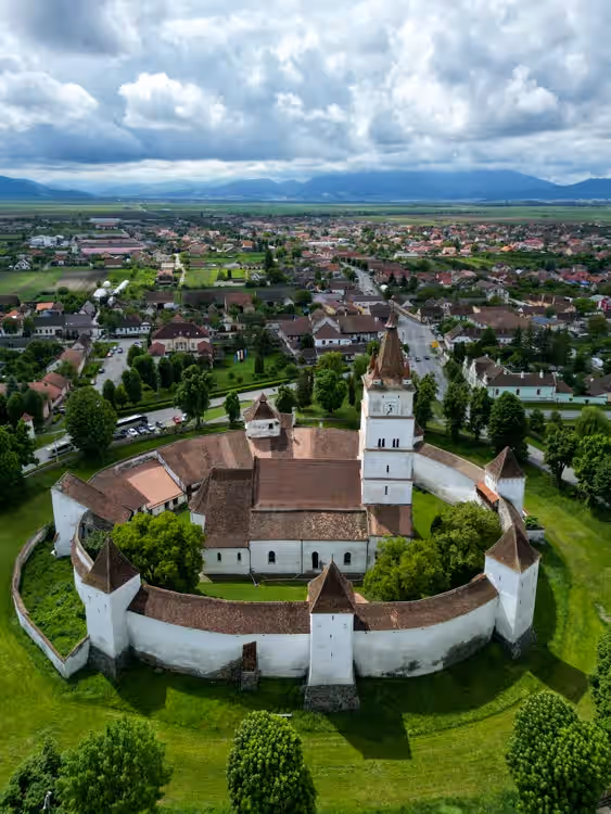 Vedere aeriană a cetății Hărman cu incinta ovală și șanțul înverzit