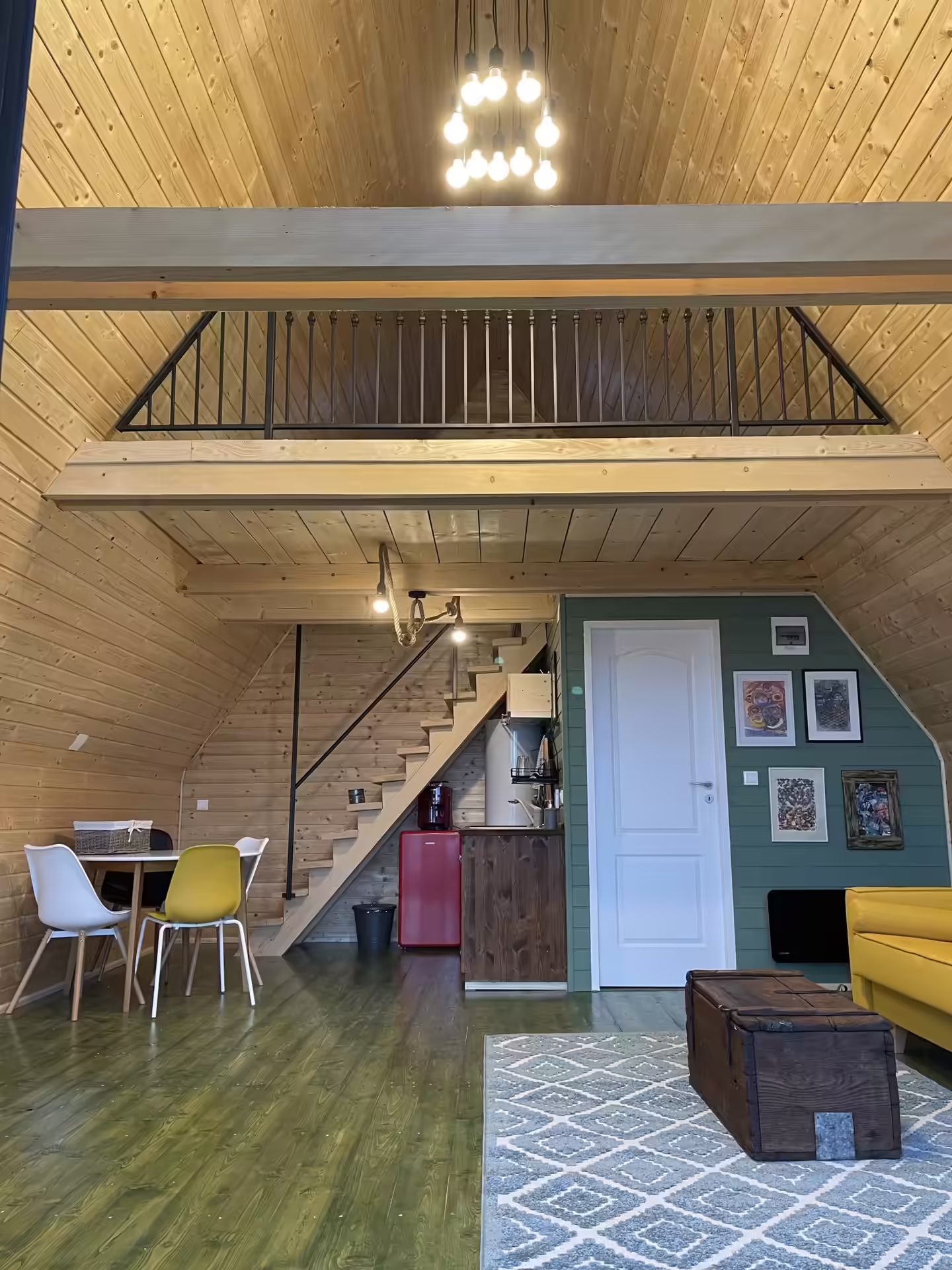 Interiorul unei cabane din lemn cu scări spre mansardă, La Noi La Munte Interiorul unei cabane din lemn cu scări spre mansardă, La Noi La Munte