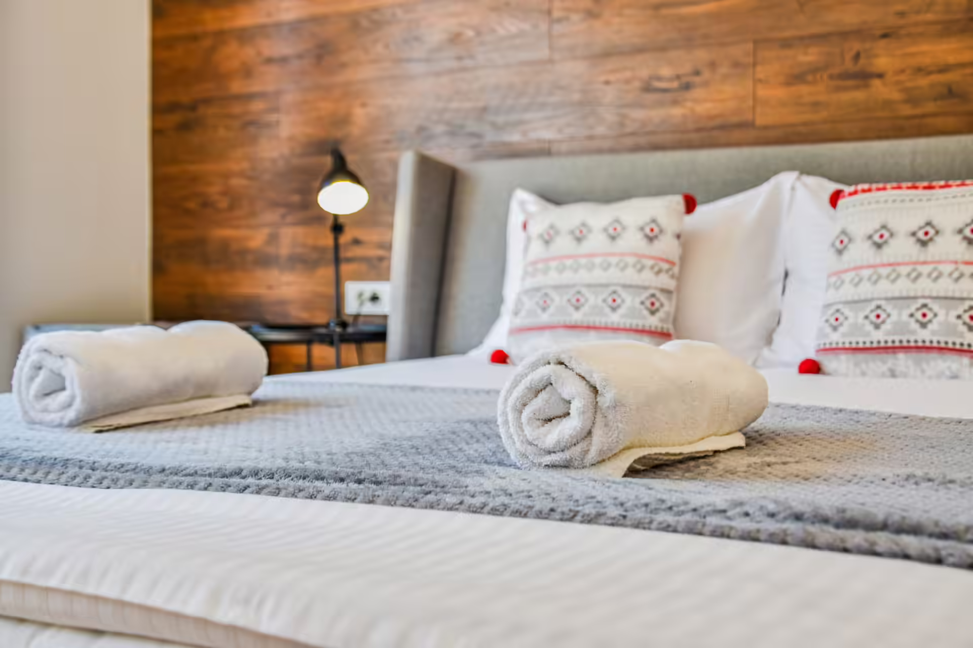 Detaliu cu perne decorative tradiționale pe patul din bungalou
