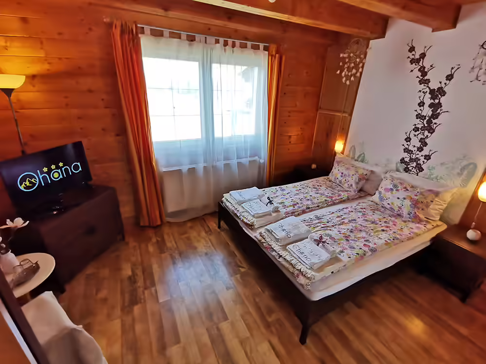 Cameră cu tăblie portocalie și prosoape pregătite pentru oaspeți la Ohana Boutique Hotel