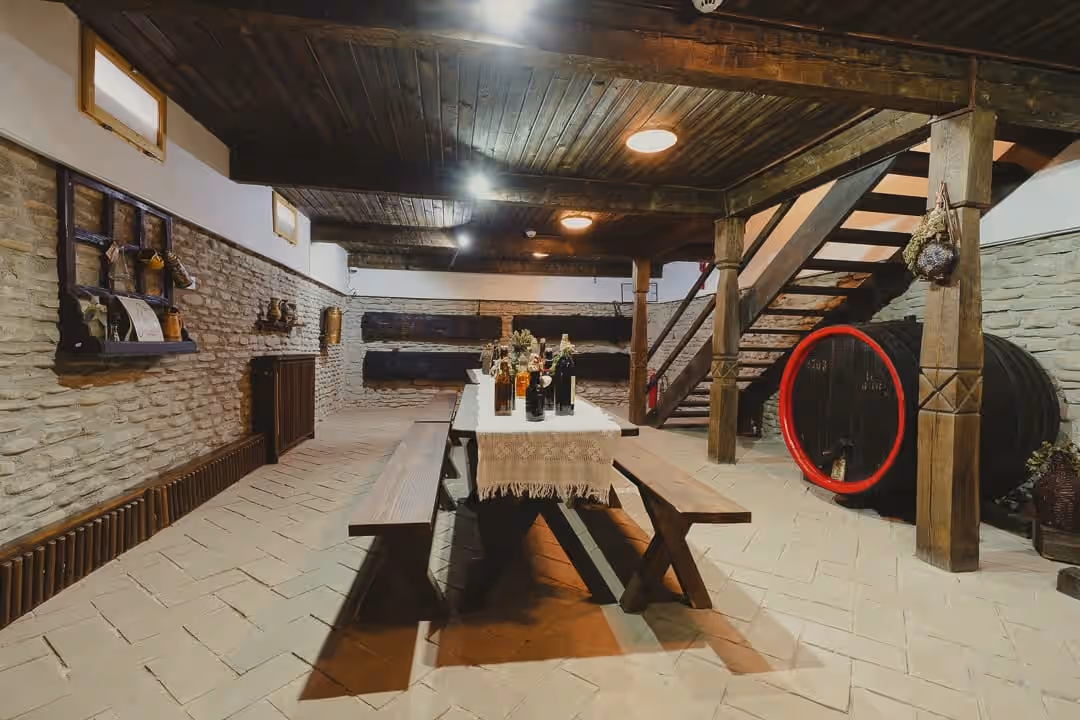 Sala de degustare din pivnița Crama 1777 cu scară de lemn Sala de degustare din pivnița Crama 1777 cu scară de lemn
