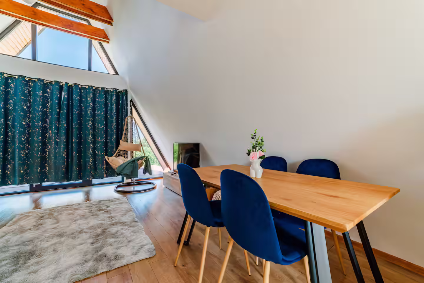 Zonă de luat masa cu masă din lemn și scaune albastre în cabana SkyAtlas Hideaway Zonă de luat masa cu masă din lemn și scaune albastre în cabana SkyAtlas Hideaway