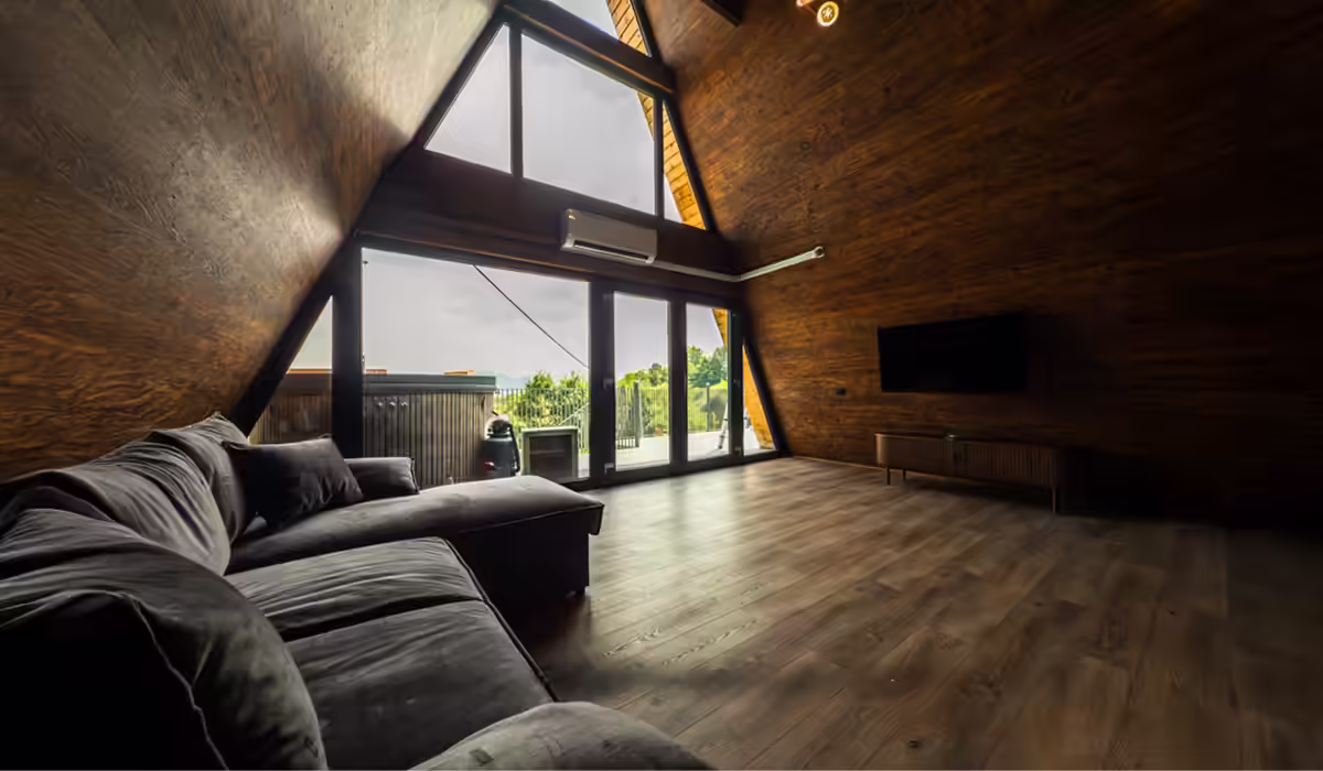 Living cu canapea generoasă în cabana A-frame AZA Chalet, Tohănița
