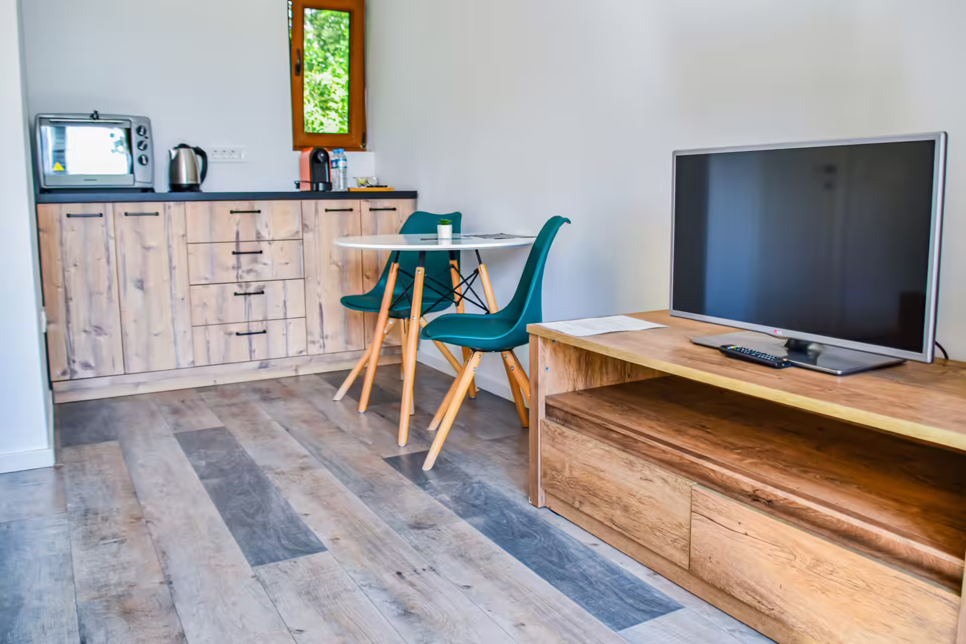 Chicinetă cu cuptor, cană electrică și televizor în bungalou