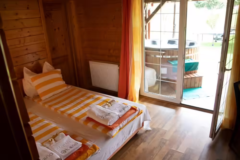 Cameră cu două paturi și ușă spre terasă la Ohana Boutique Hotel Viștișoara