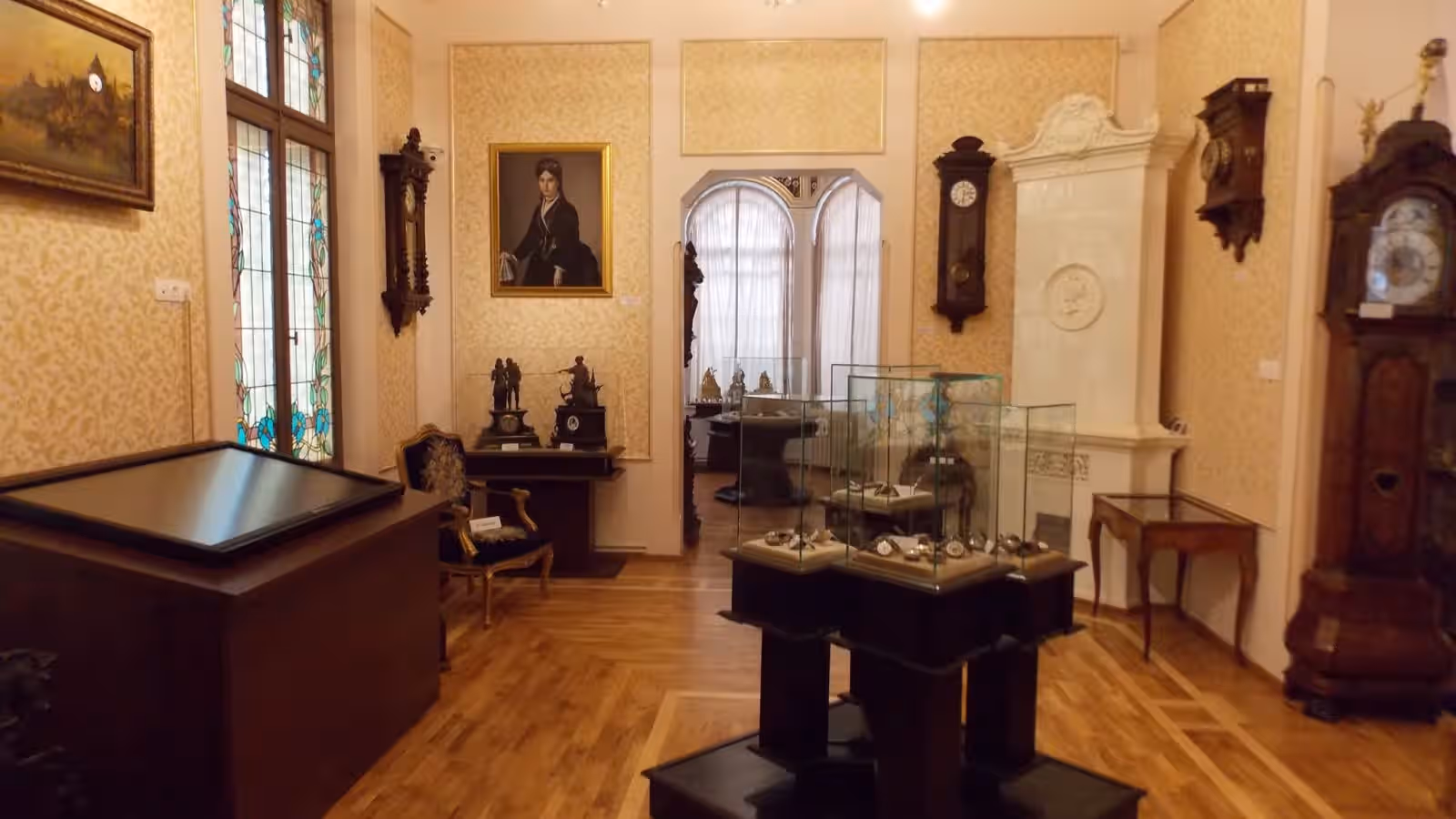 Sală cu ceasuri de perete și vitrine în Muzeul Ceasului din Ploiești