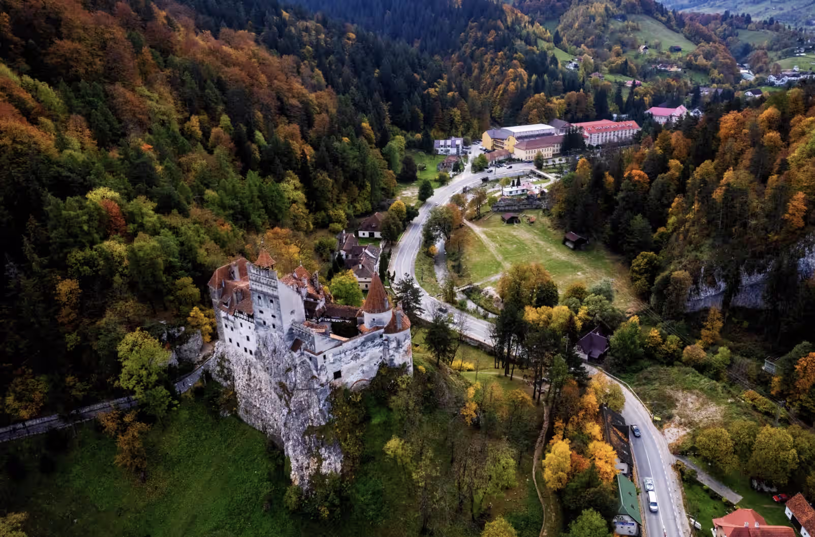 Castelul Bran și satul Bran din dronă, cu valea și drumul spre Rucăr Castelul Bran și satul Bran din dronă, cu valea și drumul spre Rucăr