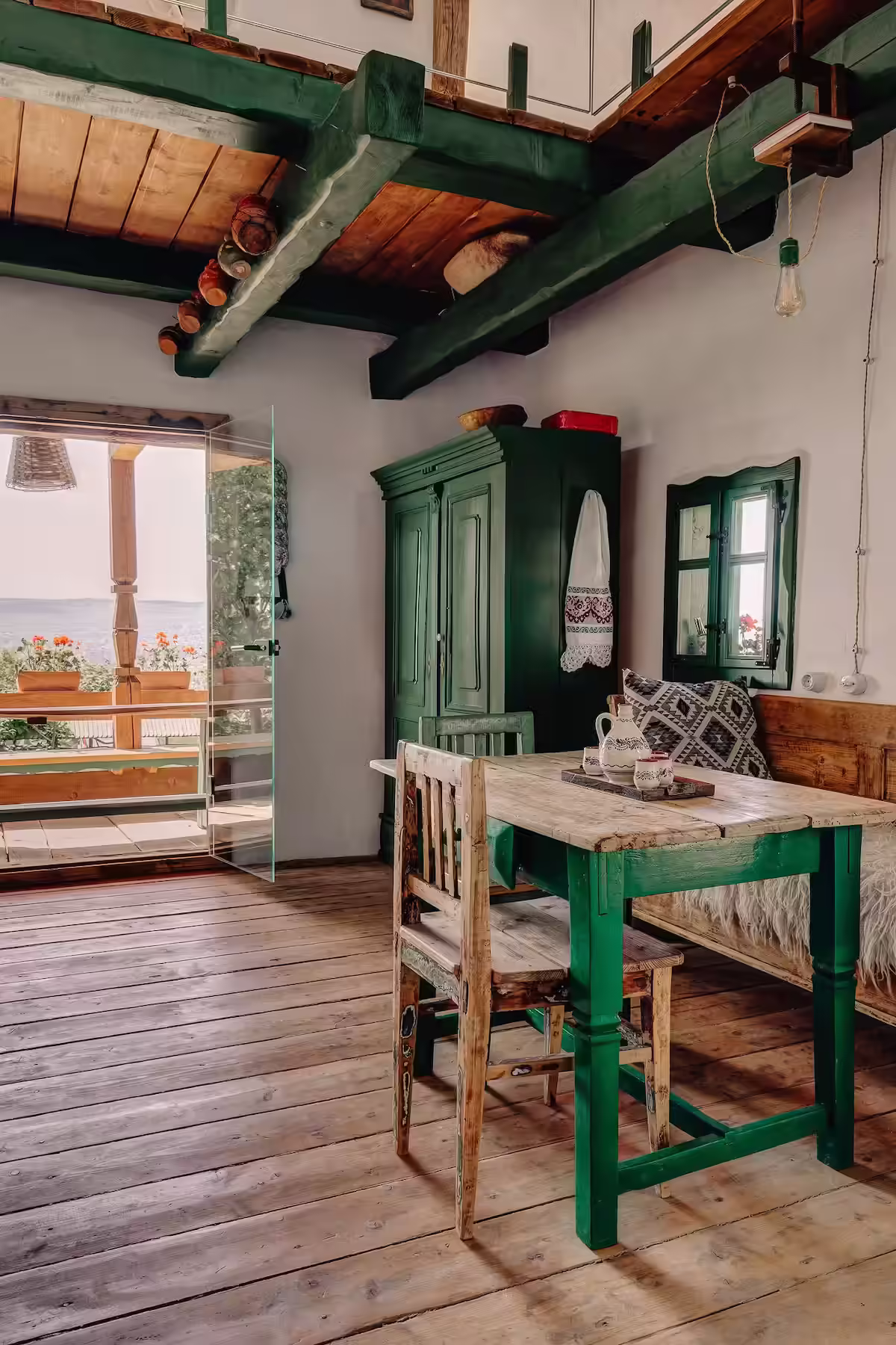 Colț de luat masa cu mobilier din lemn vopsit verde la Echoes of Vlădicu