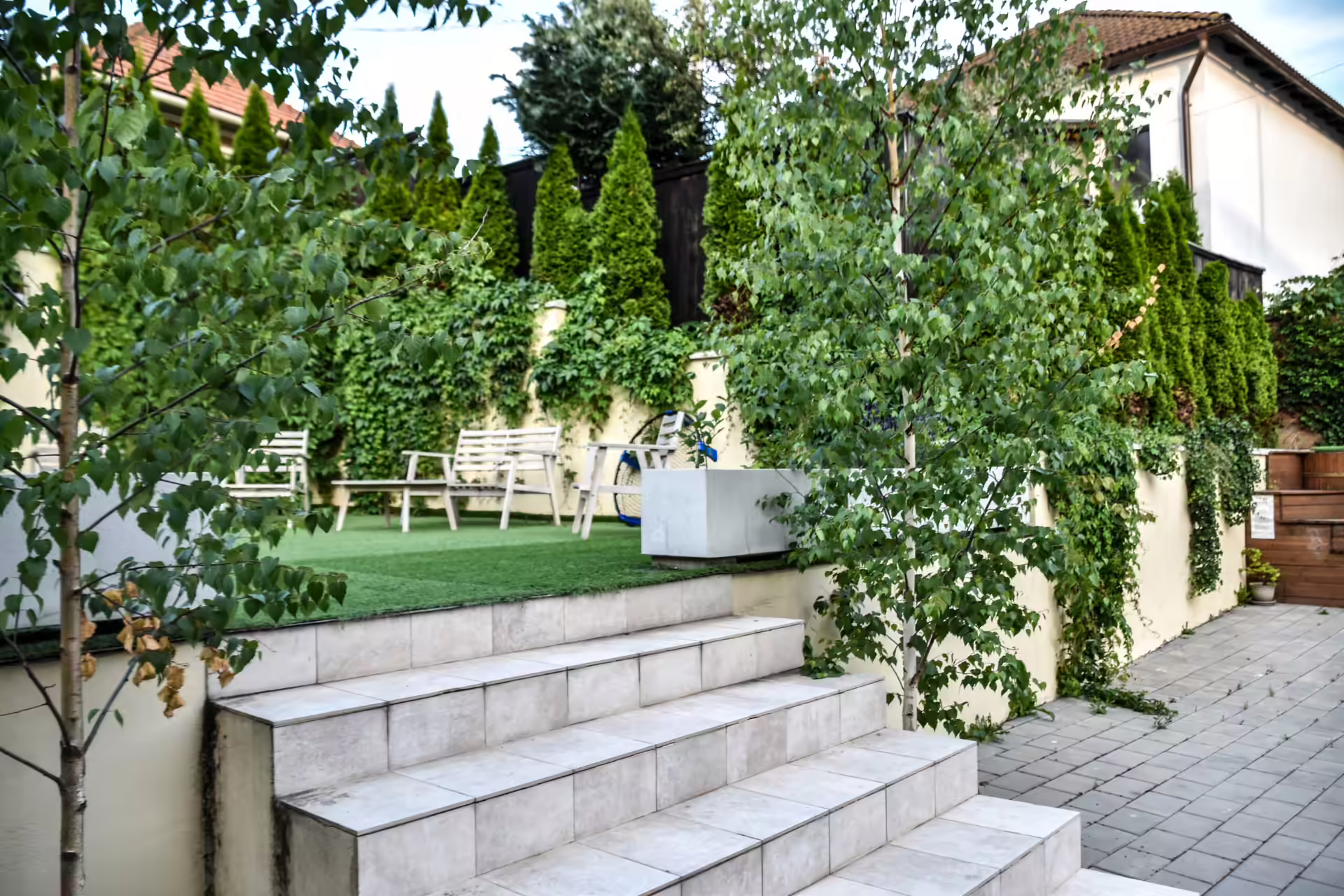 Grădina verde cu trepte din beton și arbori ornamentali la Berg House 31 Săcele Grădina verde cu trepte din beton și arbori ornamentali la Berg House 31 Săcele