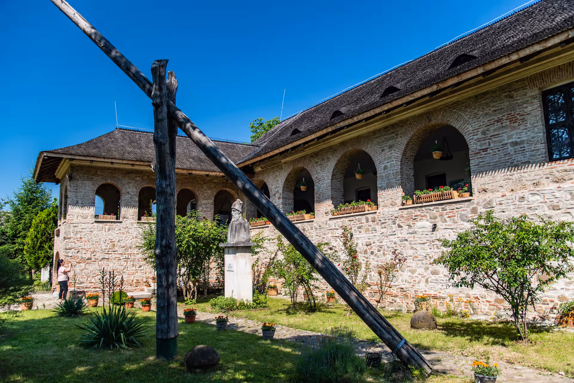 Casa Domnească Brebu cu arcade și cumpăna fântânii într-o zi de vară