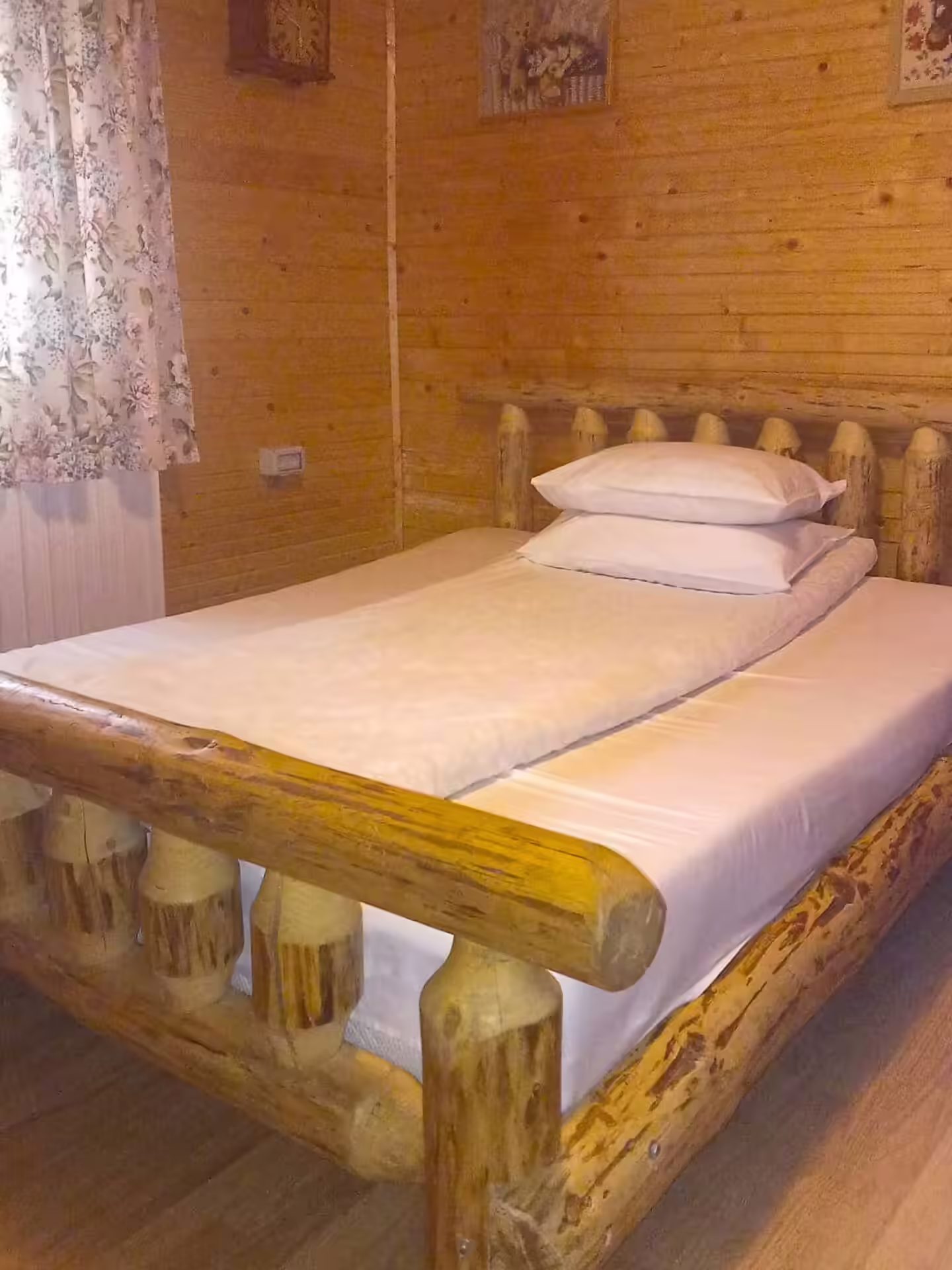 Pat rustic din lemn într-un dormitor al Cabanei din Pădurea Beliș