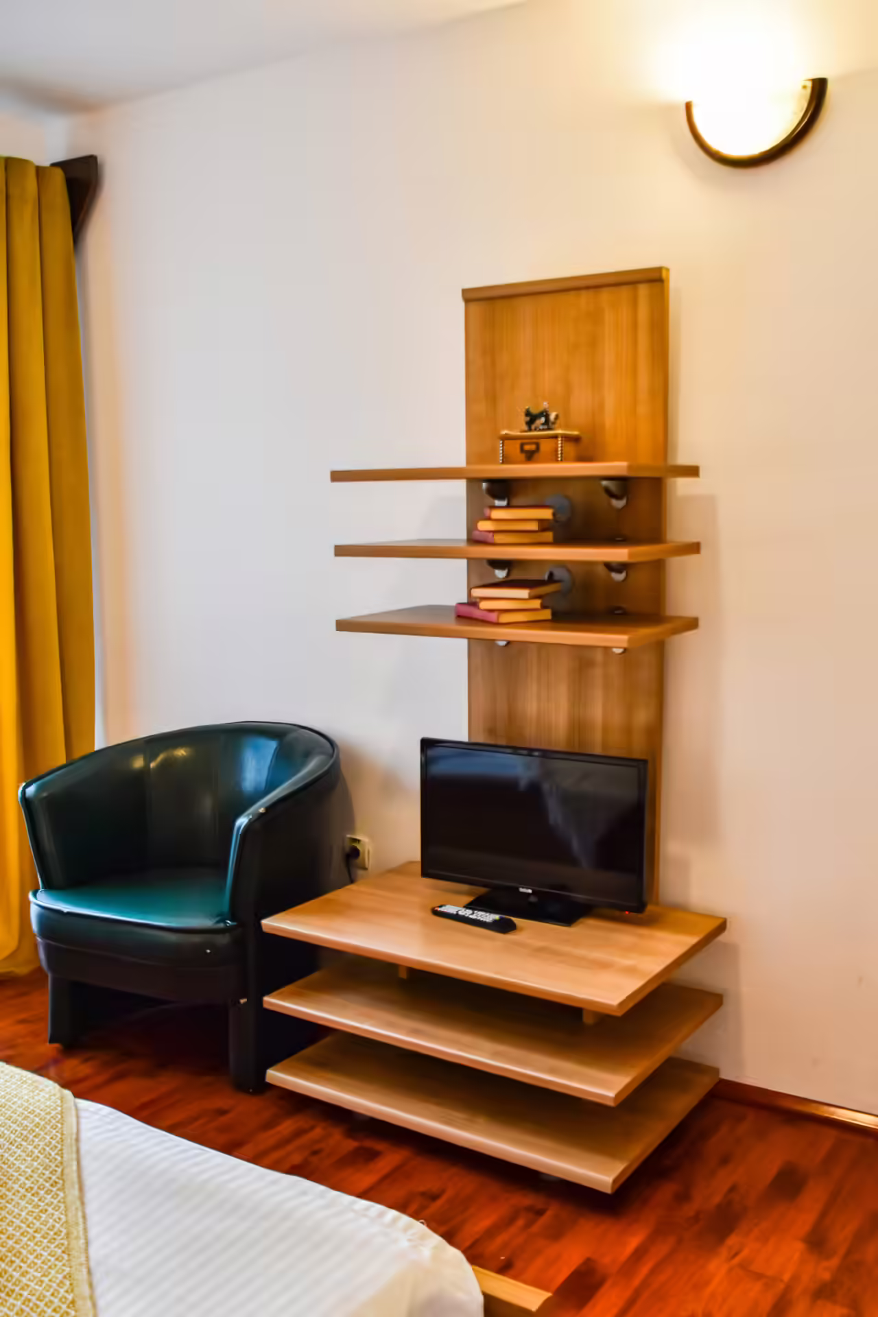 Cameră cu fotoliu, rafturi și televizor la Casa Georgea