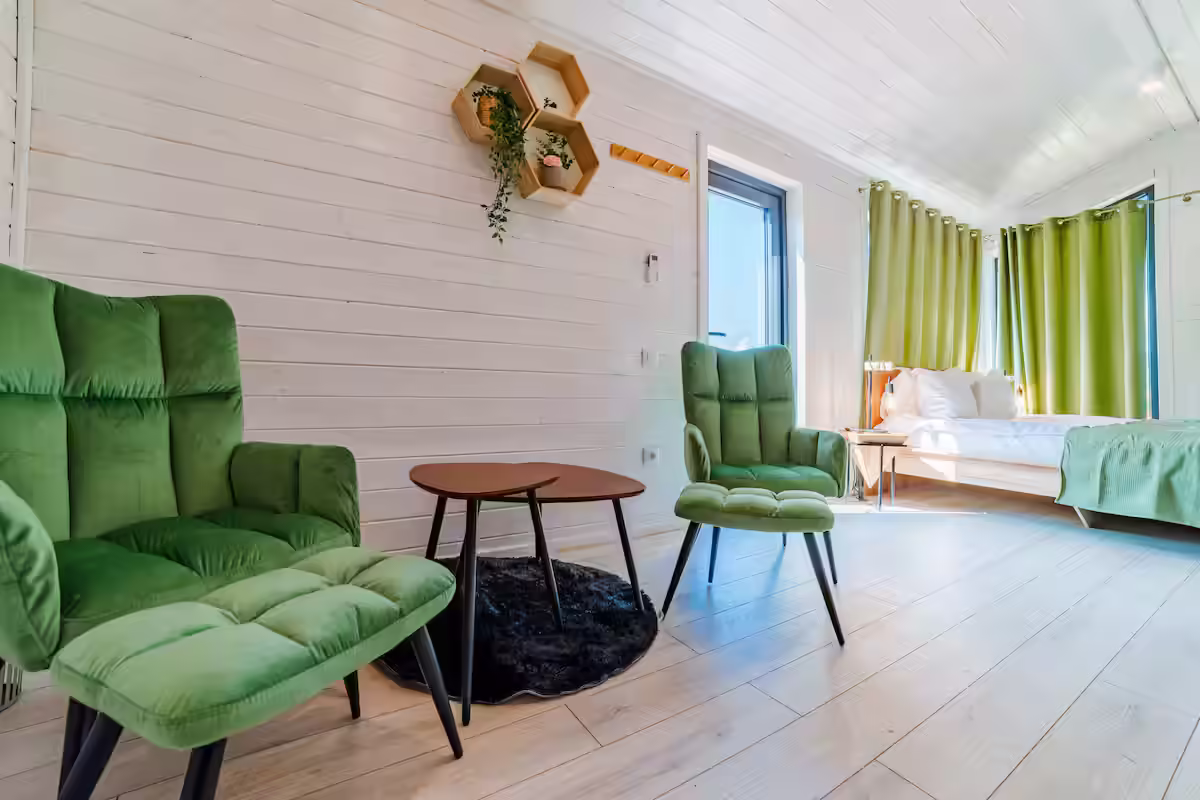 Fotolii verzi și măsuță rotundă în interiorul cabanei SkyAtlas Hideaway Fotolii verzi și măsuță rotundă în interiorul cabanei SkyAtlas Hideaway