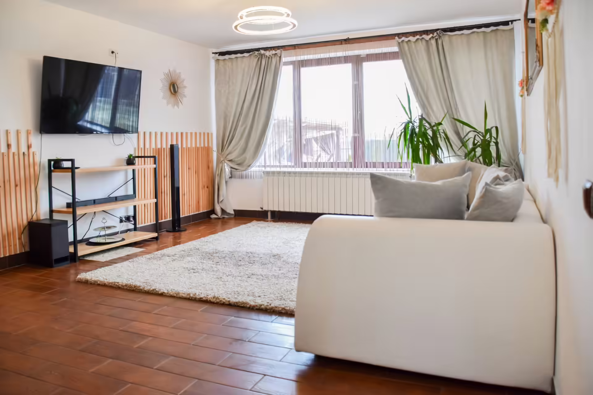 Living cu televizor și canapea albă la Vila Mik Guesthouse Living cu televizor și canapea albă la Vila Mik Guesthouse