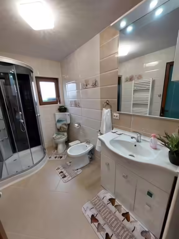 Baie cu cabină de duș și mobilier alb la Maria's Dream House