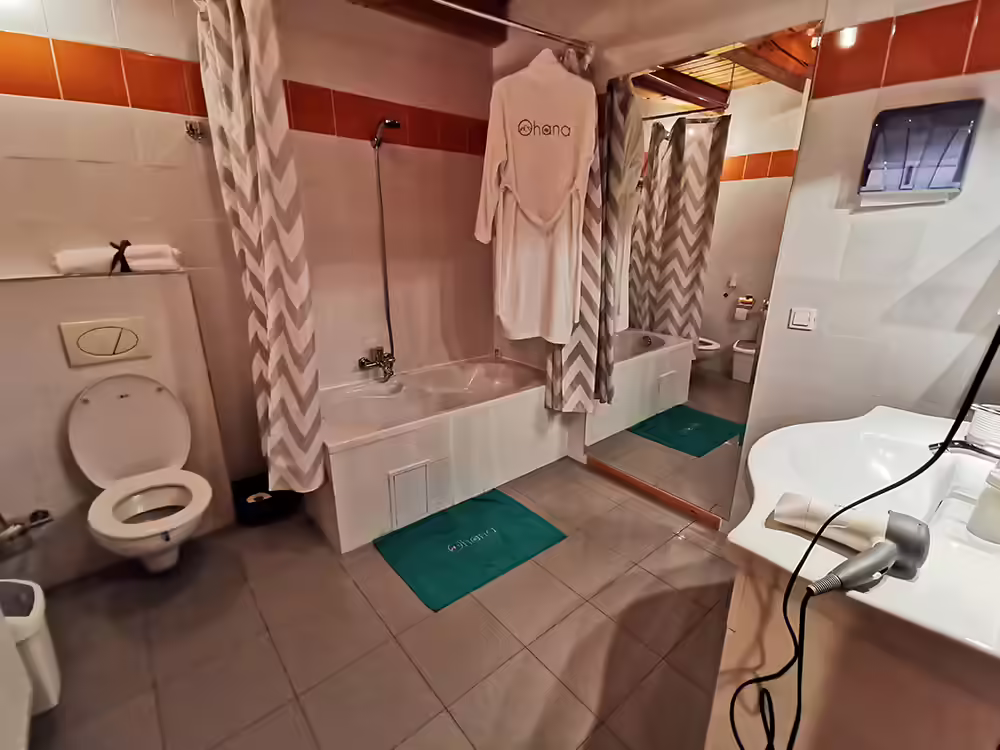 Baie cu cadă, perdea decorativă și finisaje luminoase la Ohana Boutique Hotel