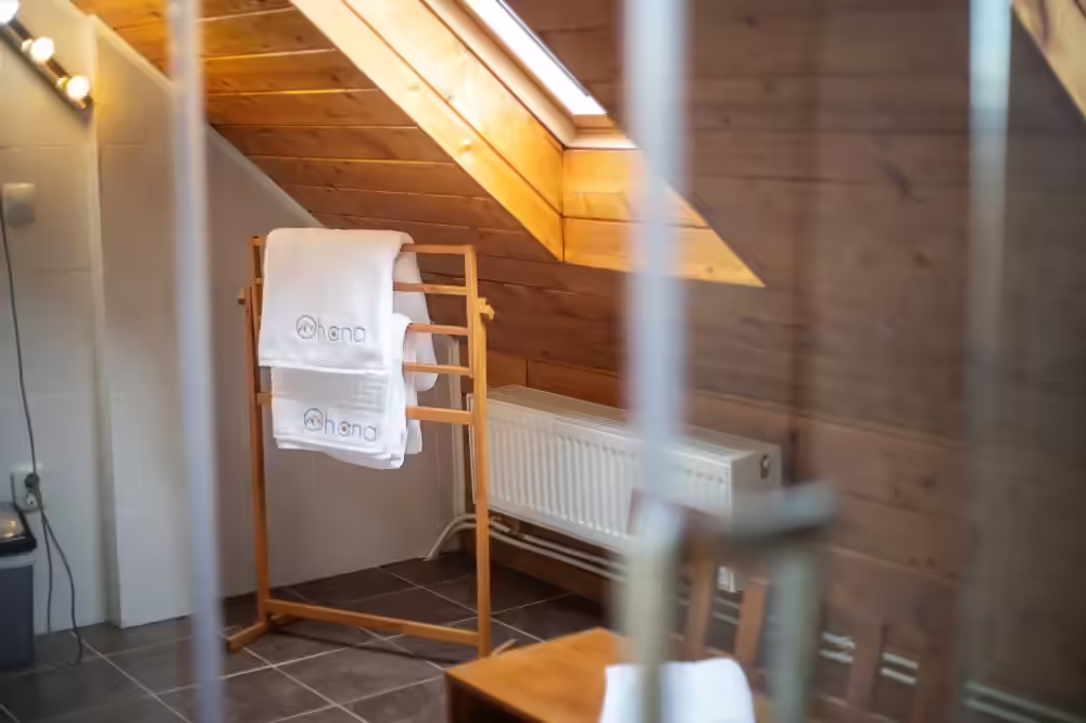 Baie cu prosoape pregătite și finisaje din lemn la Ohana Boutique Hotel