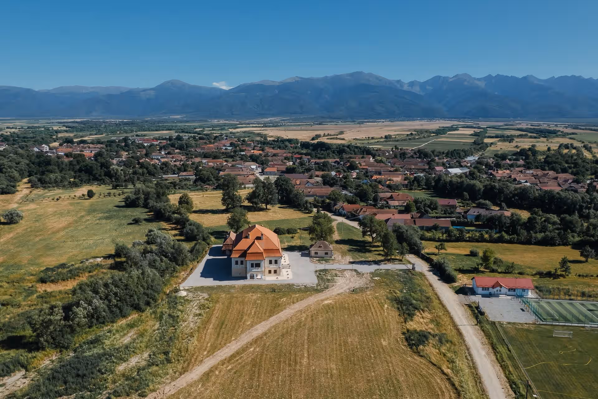 Castelul Brâncoveanu și Munții Făgărașului, panoramă aeriană de vară