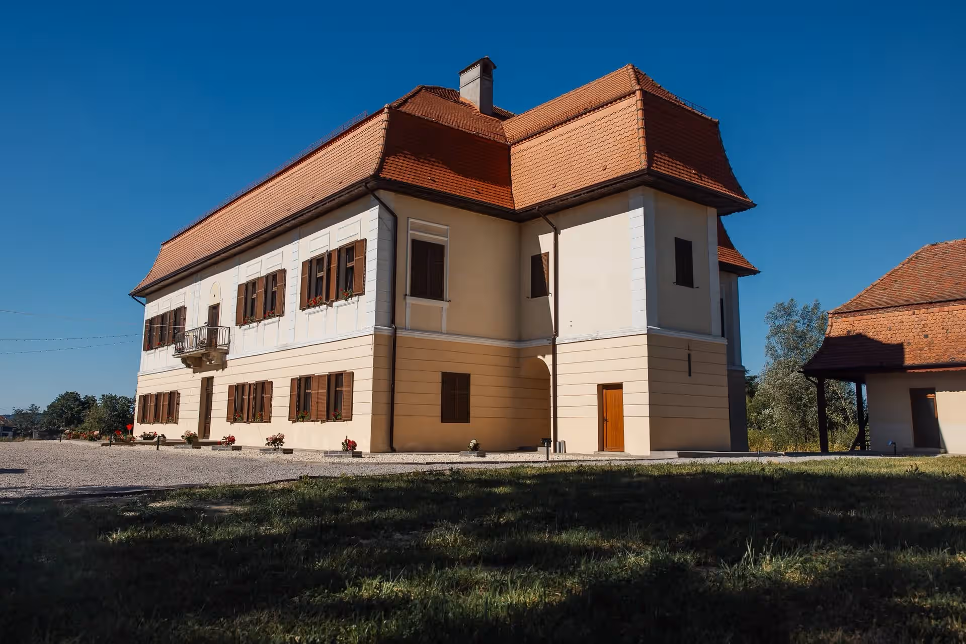 Latura Castelului Brâncoveanu cu acoperiș în pante și ferestre maro