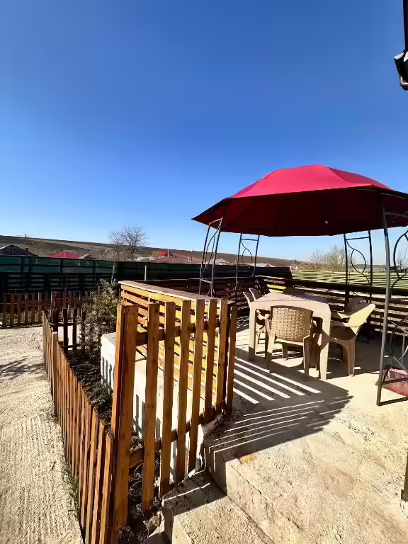 Terasă cu mobilier de exterior și umbrelă la Cabana Ursu, Iași Terasă cu mobilier de exterior și umbrelă la Cabana Ursu, Iași