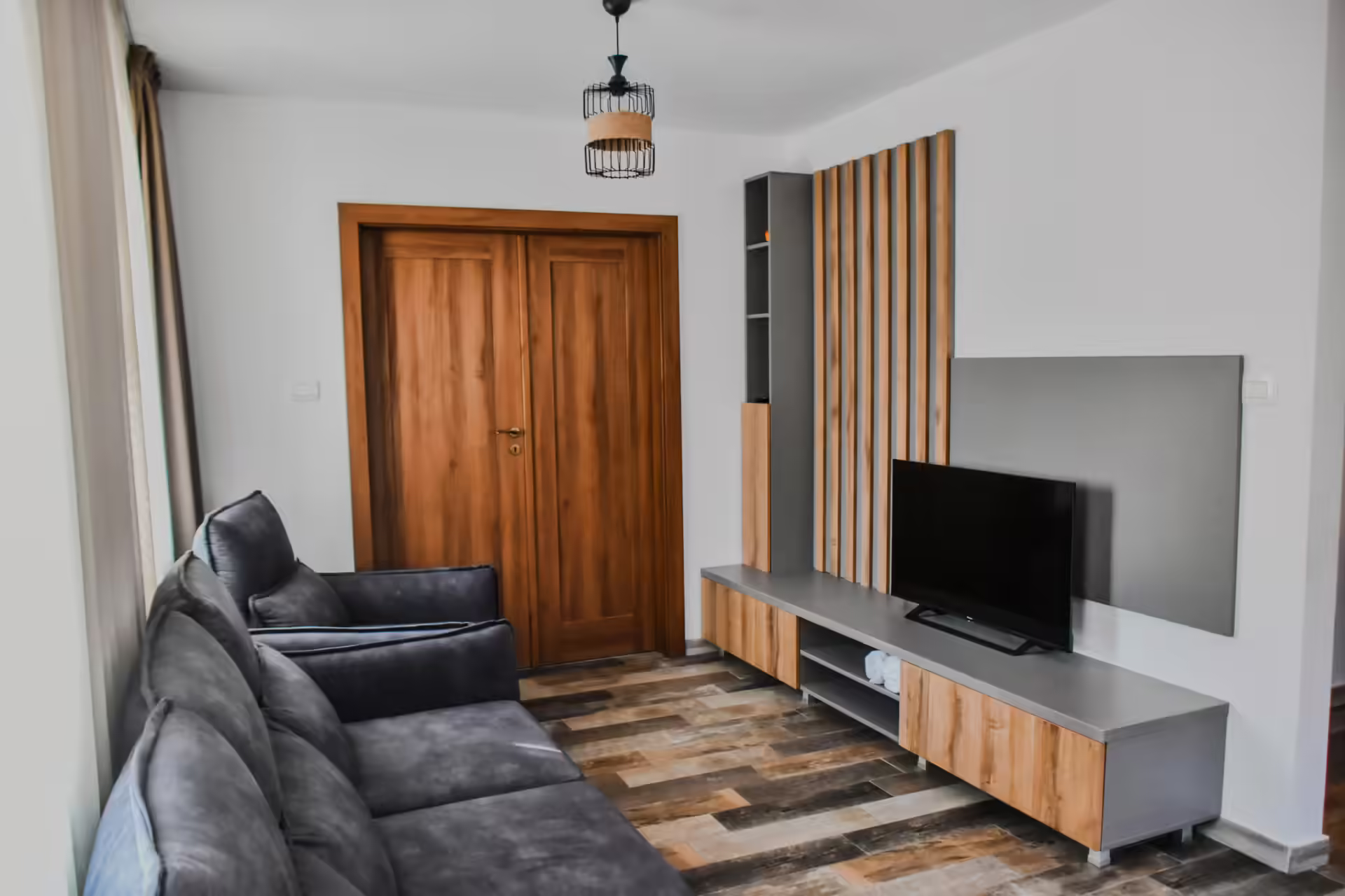 Cameră cu ușă din lemn masiv, televizor și canapea la Berg House 31 Cameră cu ușă din lemn masiv, televizor și canapea la Berg House 31