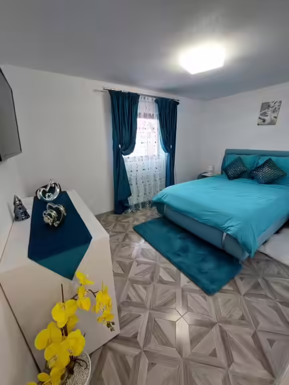 Cameră cu pat matrimonial și draperii turcoaz la Maria's Dream House