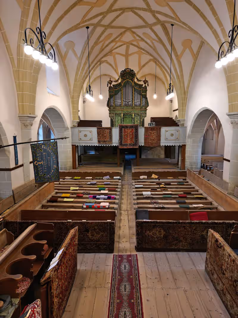 Interiorul gotic al bisericii din Hărman, cu bănci de lemn și orgă