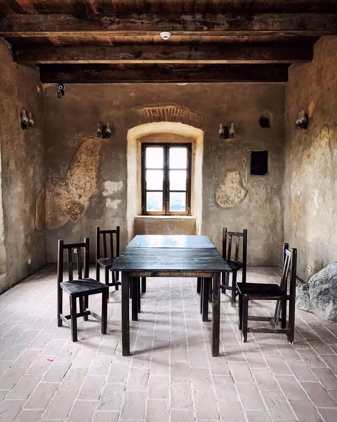 Încăpere restaurată cu masă și scaune din lemn, Cetatea Rupea