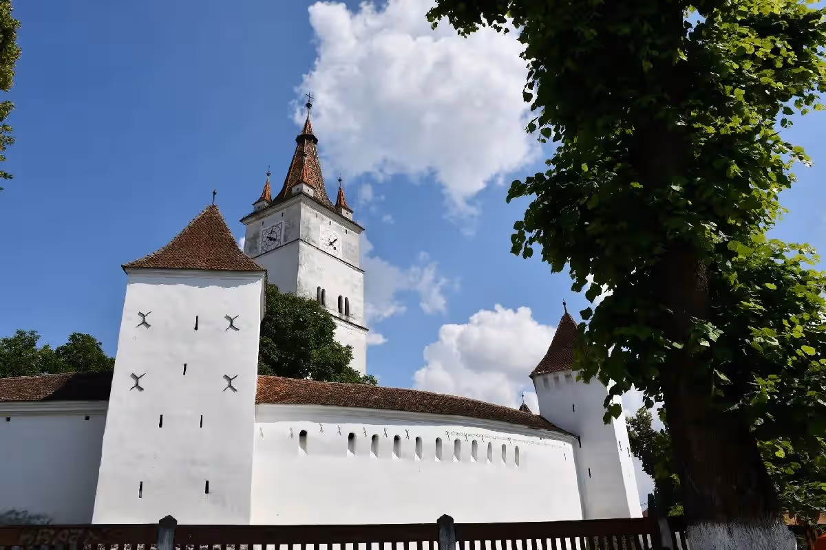 Turnul clopotniță și bastioanele Bisericii Fortificate Hărman, sub cer senin