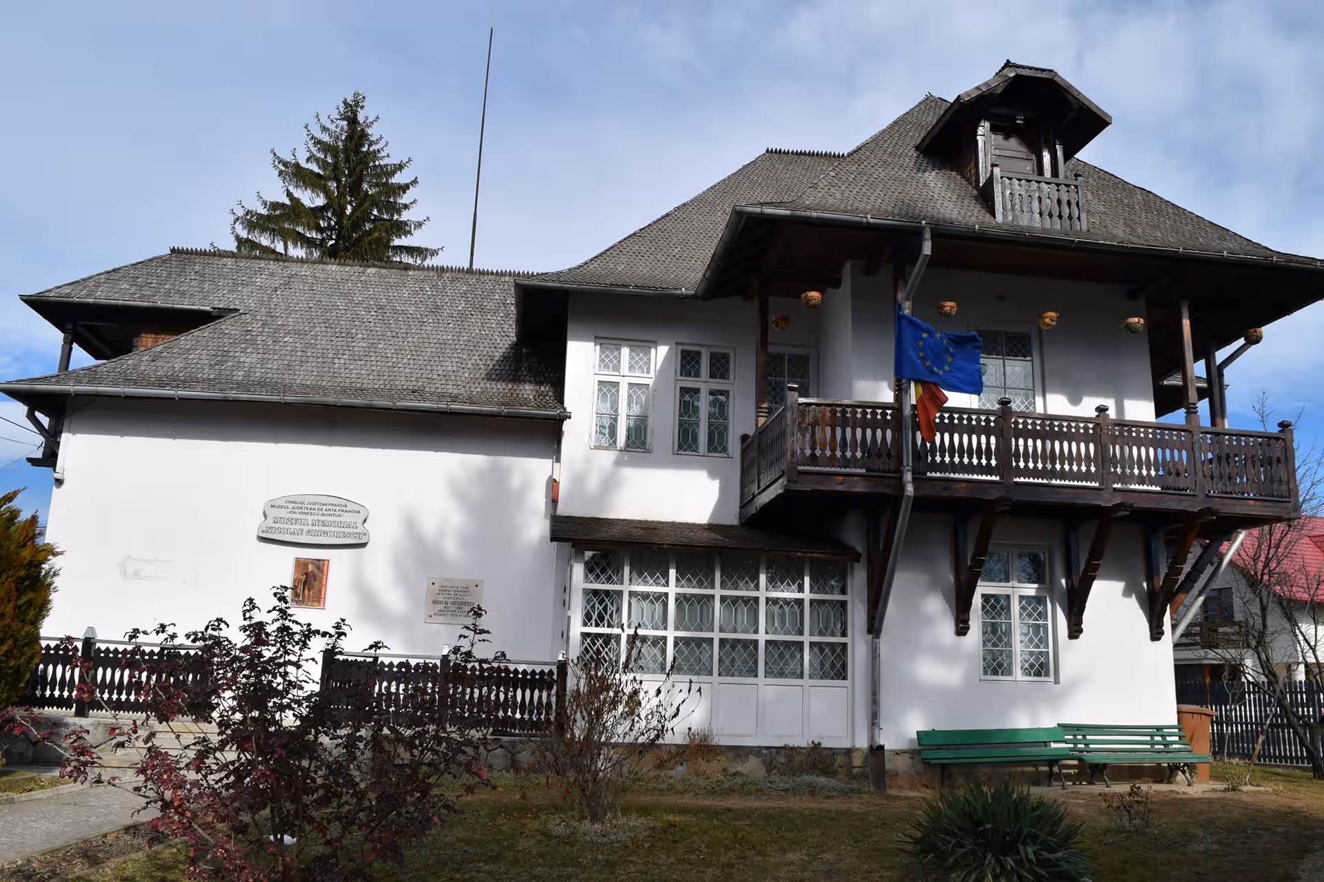 Casa memorială Nicolae Grigorescu cu acoperiș înalt și balcon de lemn