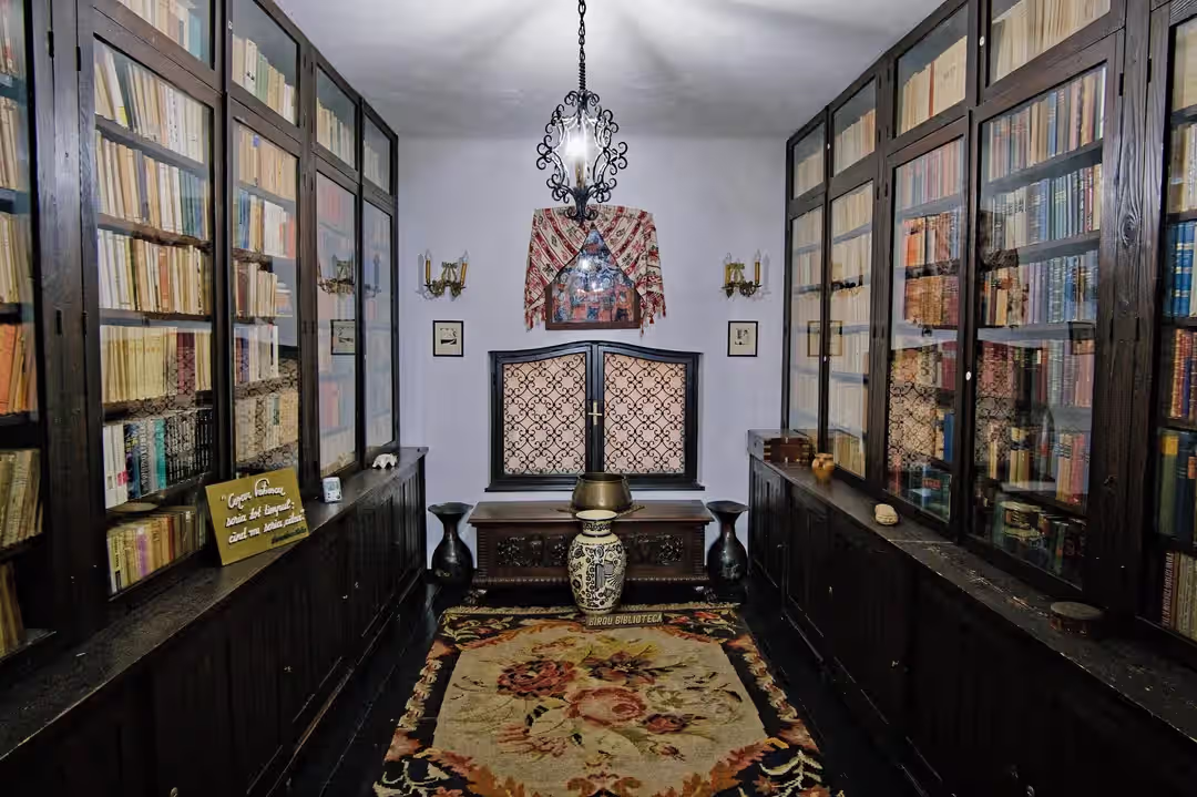 Sala bibliotecii cu rafturi de cărți și candelabru în Muzeul Cezar Petrescu Sala bibliotecii cu rafturi de cărți și candelabru în Muzeul Cezar Petrescu
