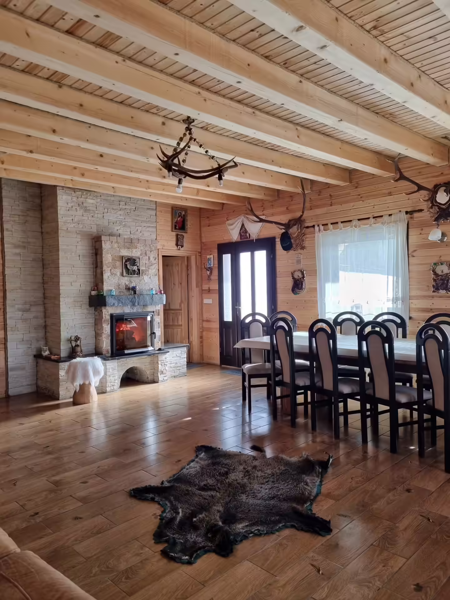 Living primitor cu zonă de dining și ferestre mari la Mountain View Chalet Broșteni Living primitor cu zonă de dining și ferestre mari la Mountain View Chalet Broșteni