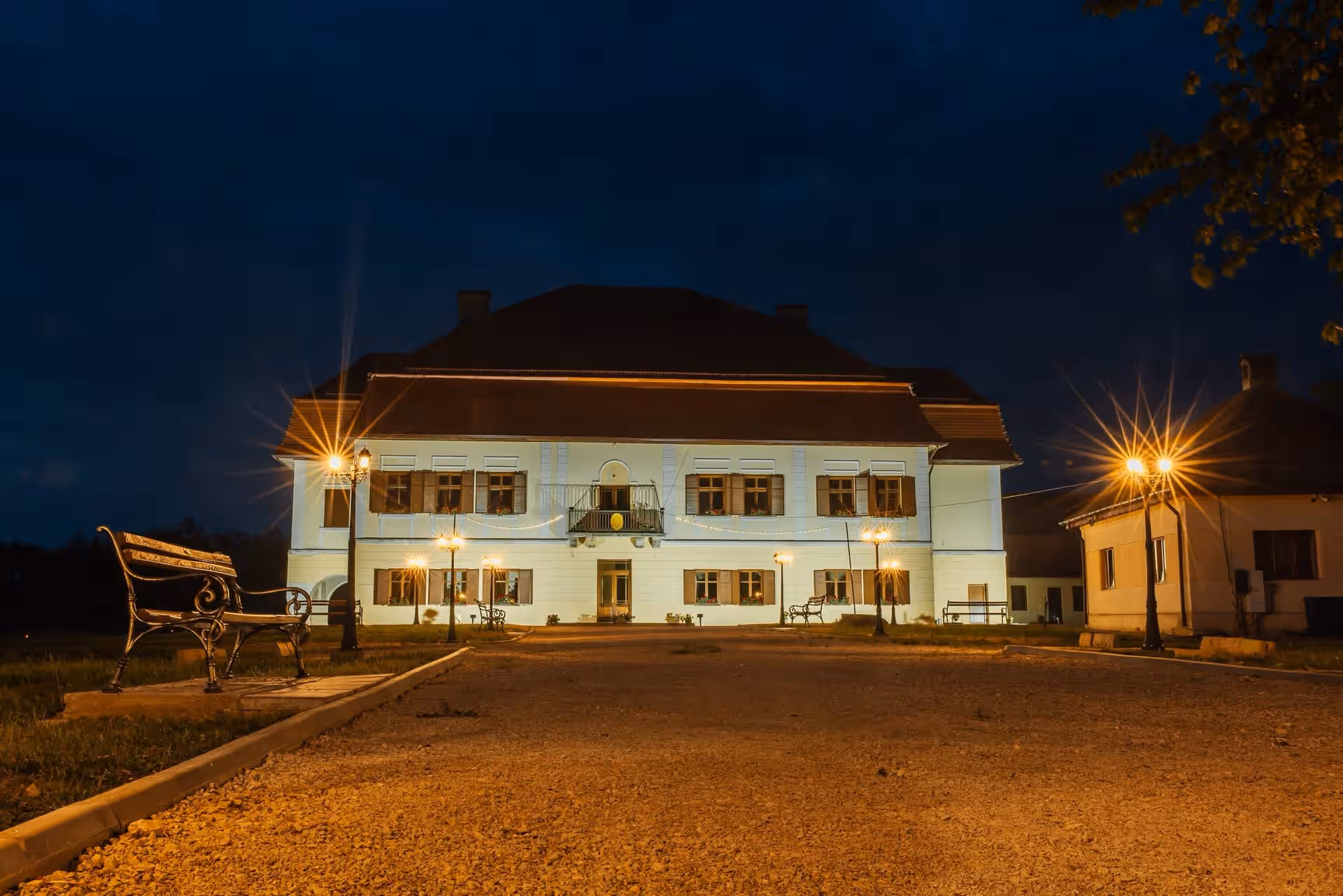 Castelul Brâncoveanu iluminat seara, cu felinare pe aleea de acces